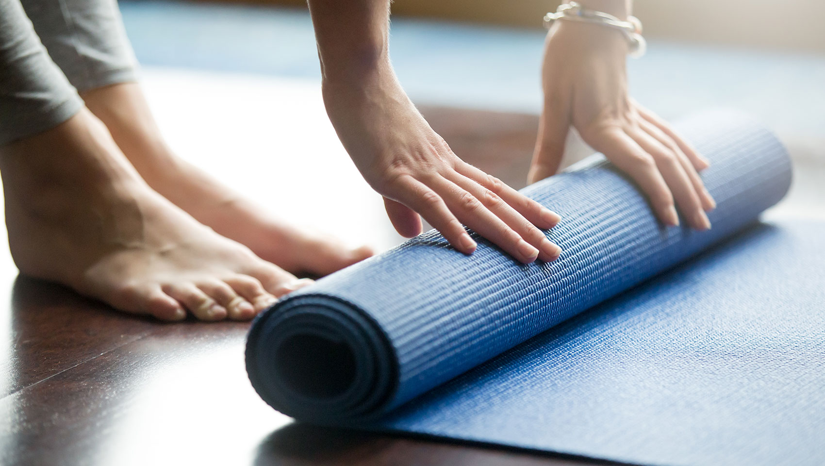 Woman rolling up yoga mat